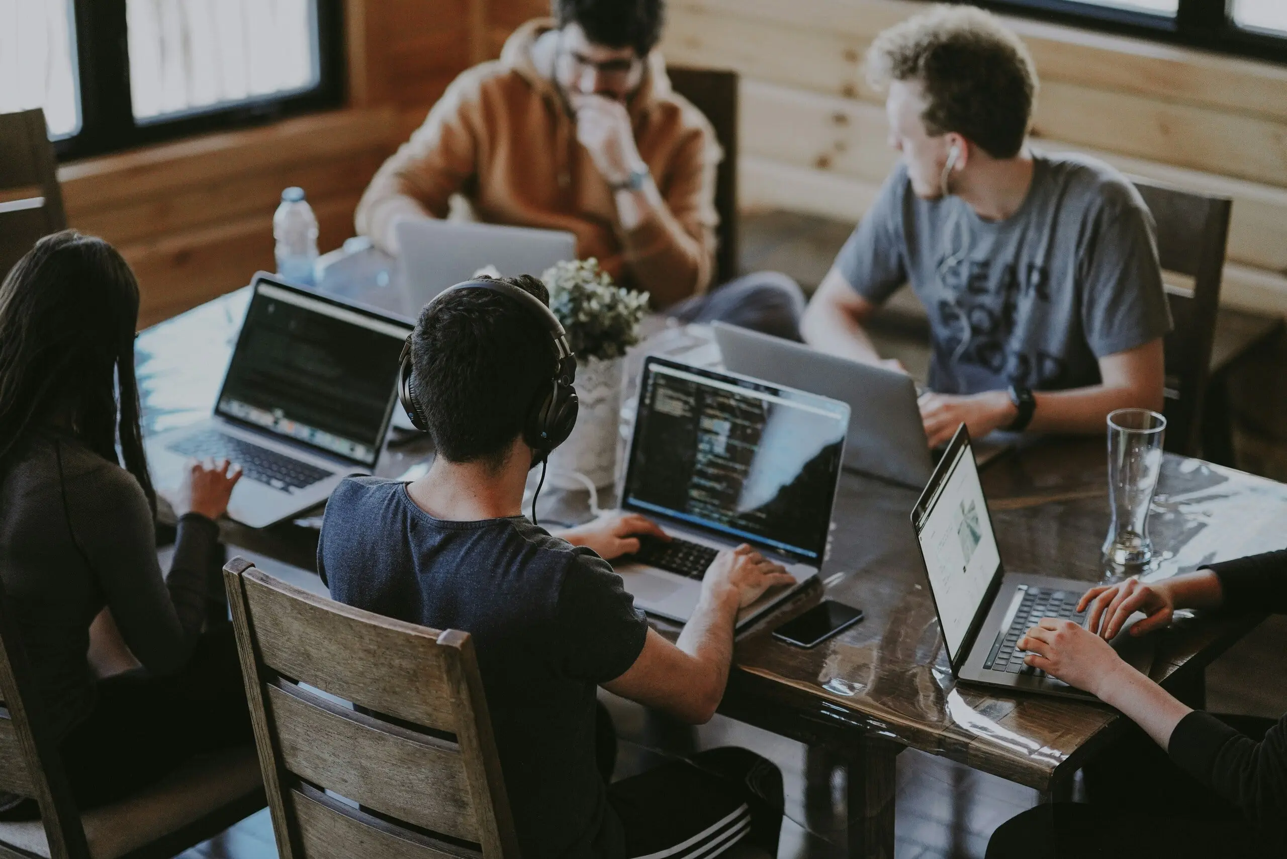 Équipe collaborative travaillant sur des projets créatifs avec des ordinateurs portables.