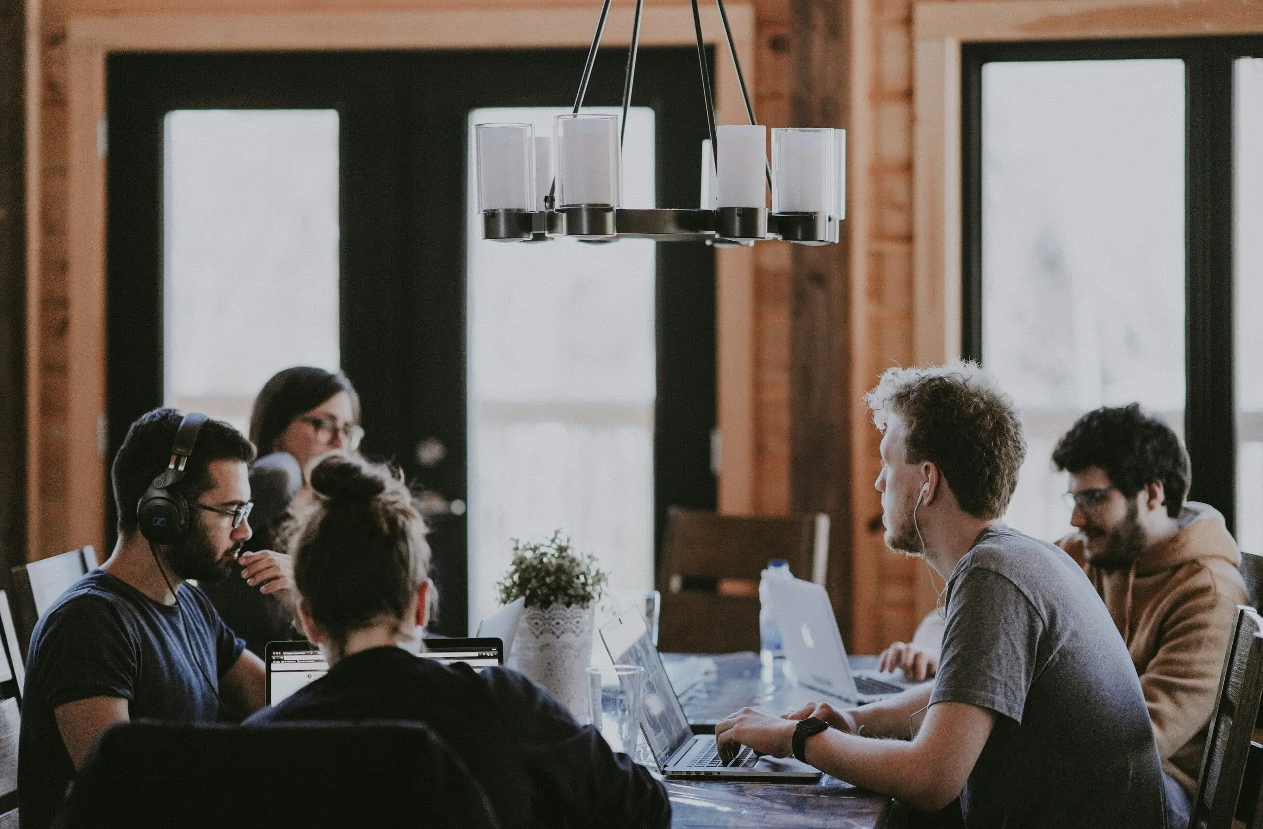 Équipe professionnelle travaillant ensemble sur des projets créatifs avec des ordinateurs portables.