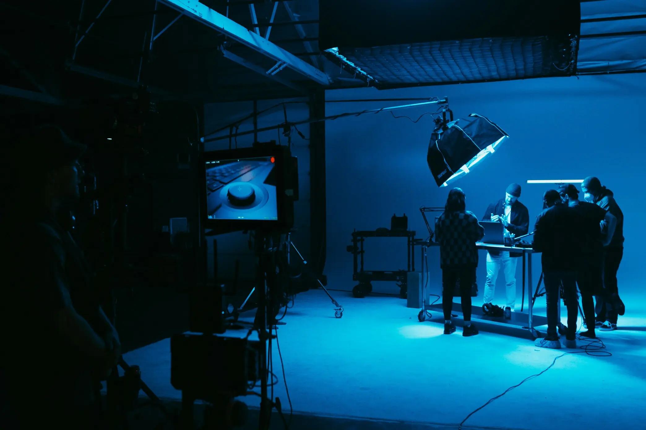 Tournage en studio avec une équipe de production vidéo sous un éclairage bleu