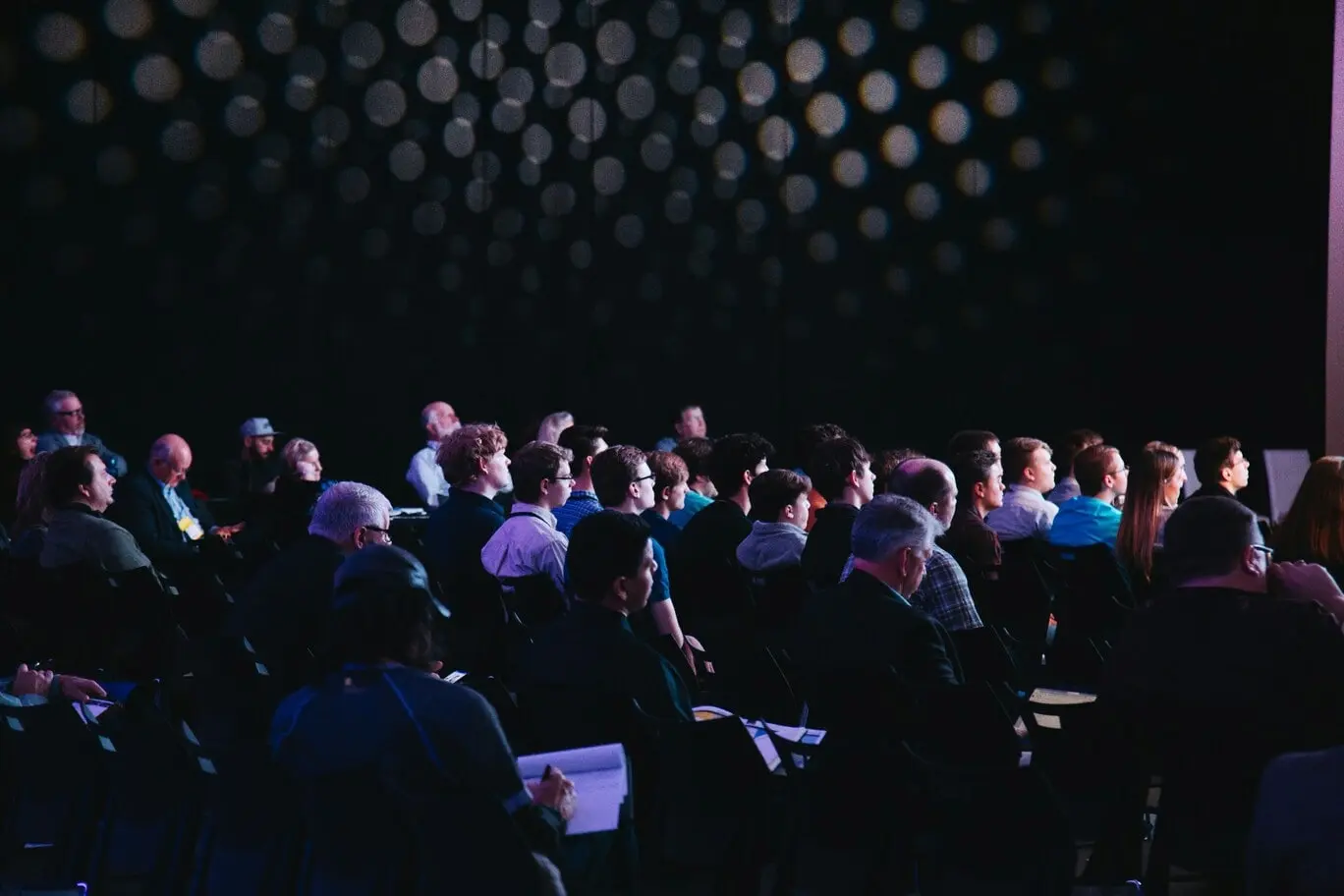 Conférence professionnelle avec participants assistés à une présentation lors d’un événement institutionnel.